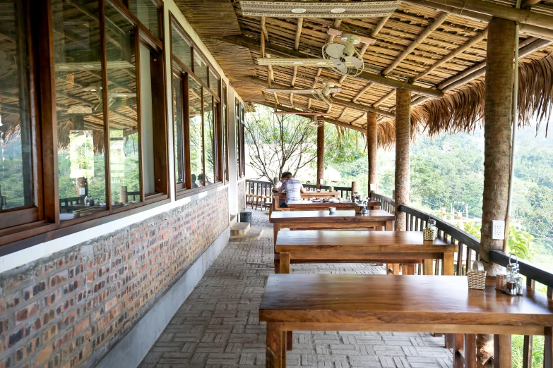 a row of tables sitting on the side of a building, mountainous jungle setting, bao phan, profile image, patio