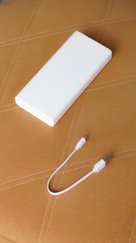 a white power bank sitting on top of a table, an album cover, trending on pexels, jakarta, cables, analog photo, 1