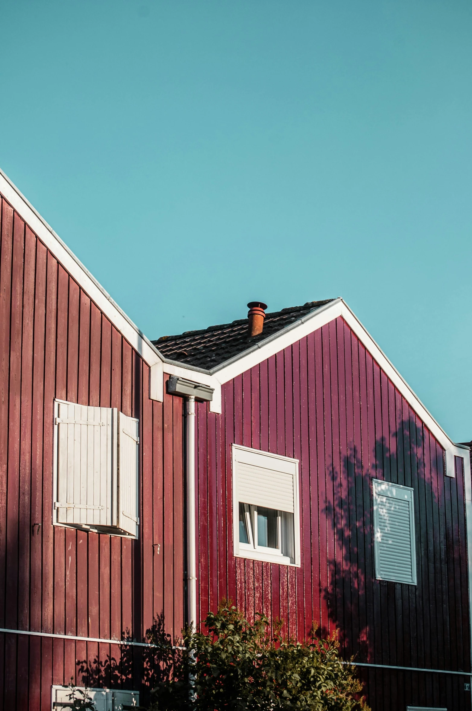 a couple of red houses sitting next to each other, a picture, pexels contest winner, modernism, galvalume metal roofing, nordic pastel colors, maroon and white, skewed shot