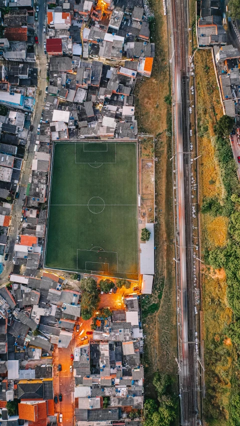 an aerial view of a soccer field in a city, an album cover, by Carey Morris, unsplash contest winner, location ( favela ), ffffound, taiwan, brown