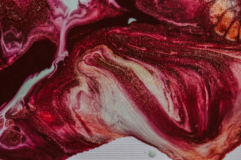a close up of a piece of food on a table, an ultrafine detailed painting, inspired by Anish Kapoor, trending on pexels, process art, magenta colours, metallic red, made of liquid, swirling fabric