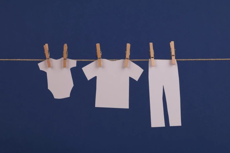 clothes hanging on a clothes line on a blue background, inspired by Rachel Whiteread, pexels contest winner, diaper-shaped, dad bod, made from paper, plain white tshirt