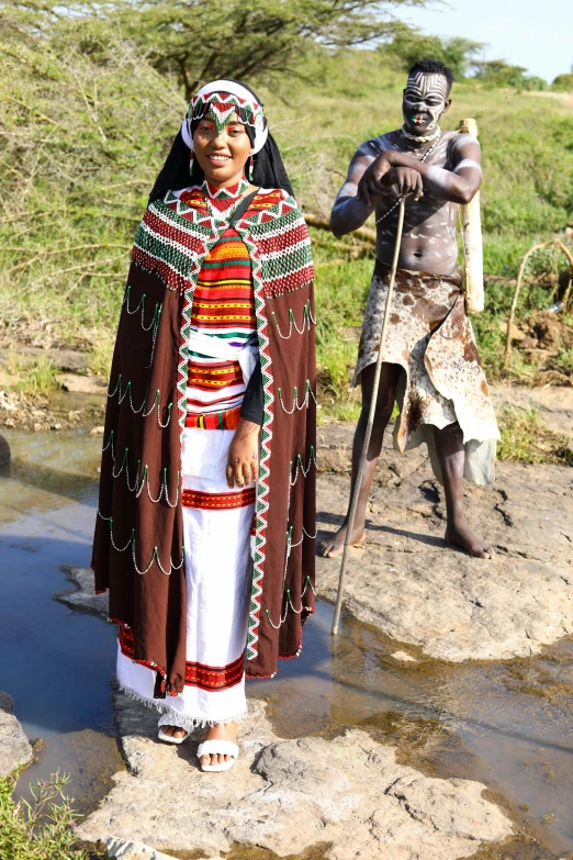 a couple of people that are standing in the dirt, inspired by Afewerk Tekle, hurufiyya, crossing the river, wearing authentic attire, on location, slide show