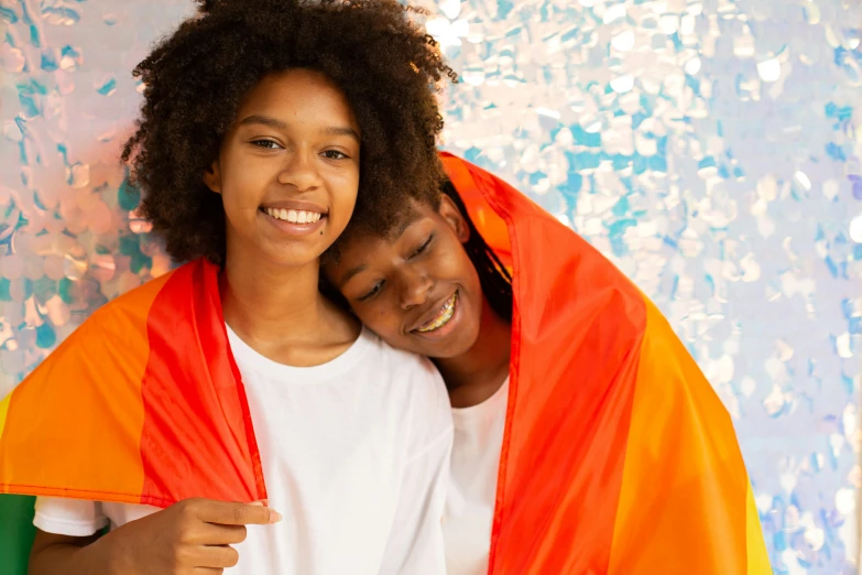 a man and a woman wrapped up in a blanket, an album cover, by Lily Delissa Joseph, shutterstock contest winner, lgbt flag, vibrant orange, young girls, expressing joy