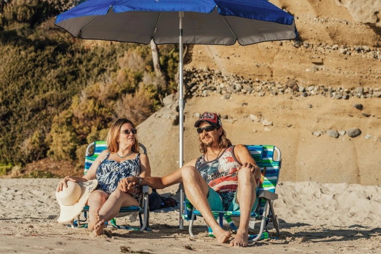 two women sitting under an umbrella on the beach, a portrait, unsplash, renaissance, hollister ranch, men and women, in a sun lounger, avatar image