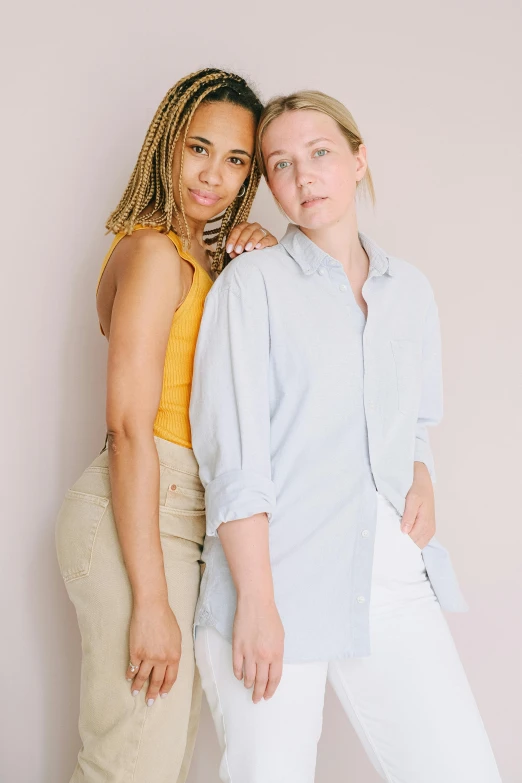 a couple of women standing next to each other, a portrait, by Ellen Gallagher, trending on unsplash, light skin tone, studio shoot, lesbian, infp young woman