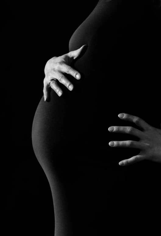 a black and white photo of a pregnant woman, inspired by Robert Mapplethorpe, pixabay, sleek hands, round-cropped, - photorealistic, 27