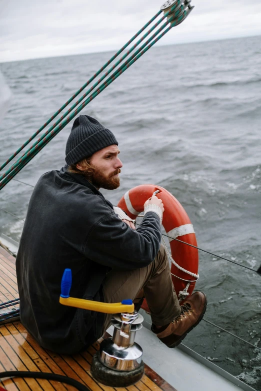 a man sitting on the deck of a boat, wearing beanie, subsurface scandering, man holding a balloon, waiting