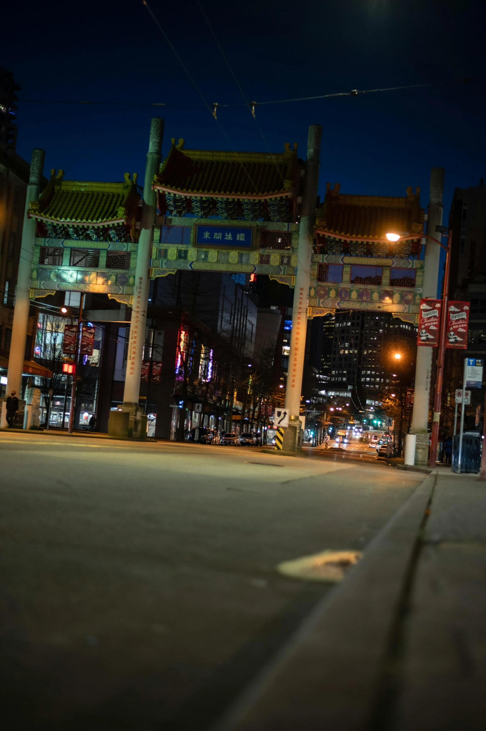 a man riding a skateboard down a street at night, chinese architecture, cleveland, archway, gta chinatown