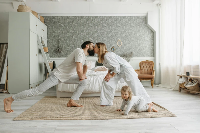 a family poses for a picture in their bedroom, by Adam Marczyński, pexels contest winner, couple kissing, plain background, crawling towards the camera, profile image