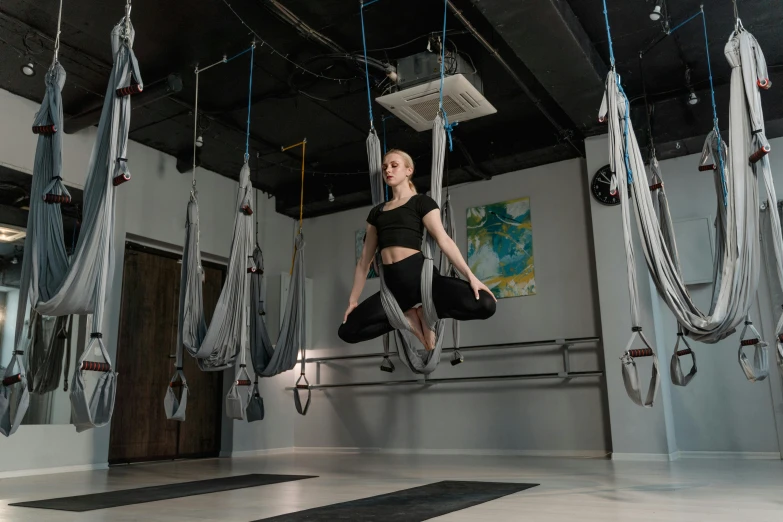 a woman flying through the air in a gym, by Emma Andijewska, avatar image