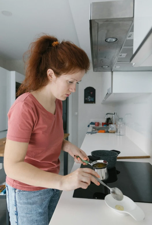 a woman standing in a kitchen preparing food, trending on reddit, a redheaded young woman, production still, avatar image, student