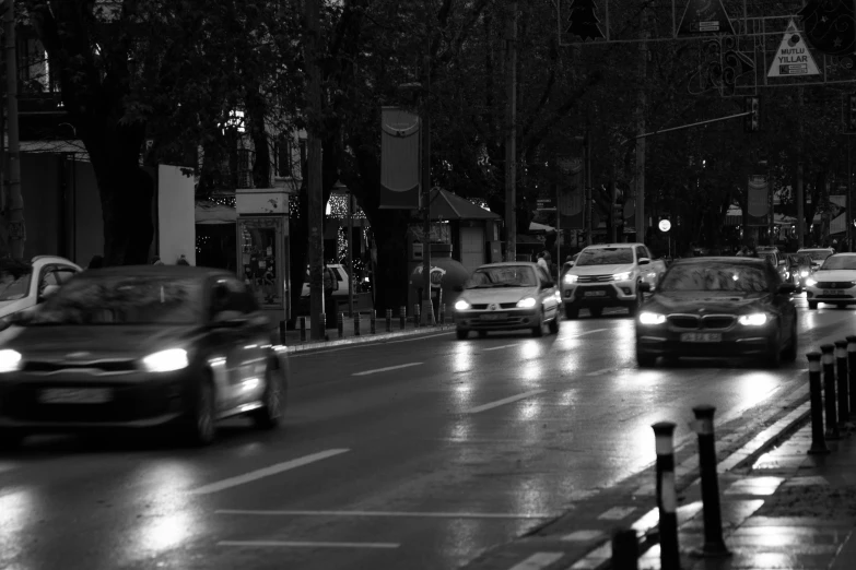 a black and white photo of a city street at night, a black and white photo, by Tamas Galambos, pexels contest winner, realism, car traffic, day after raining, romanian, fast movement