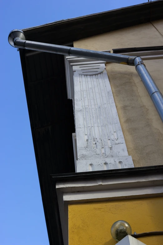 a street light hanging off the side of a building, inspired by Lucio Fontana, interesting details, in legnica, relief, sundial