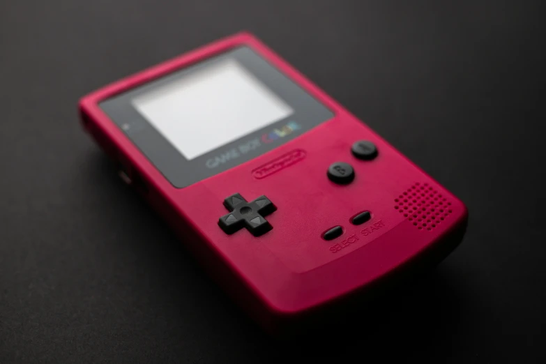 a pink gameboy sitting on top of a table, unsplash, it has a red and black paint, on a gray background, game case, 1 9 8 0 s tech