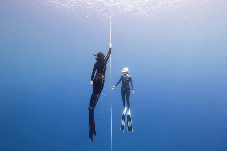 a couple of people that are in the water, bottom of ocean, hanging rope, swimming to surface, zenobia