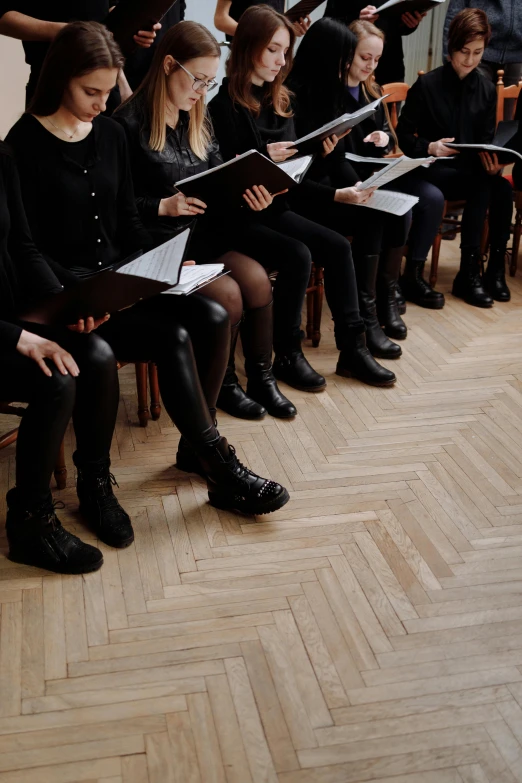 a group of people that are sitting in a room, by Nina Hamnett, antipodeans, funeral, in a row, student, dressed in black