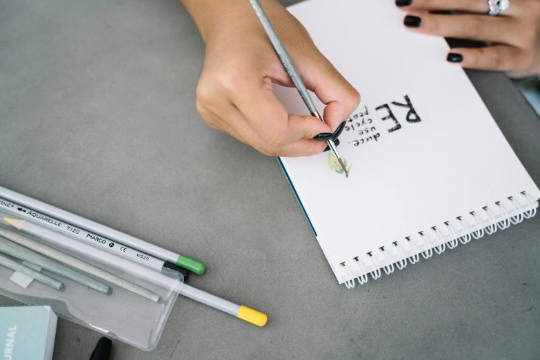 a close up of a person writing on a notebook, a drawing, trending on pexels, academic art, copic marker, detailed letters, background image