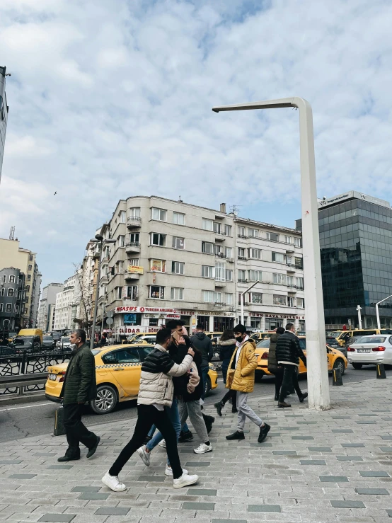 a group of people walking across a street, a photo, inspired by Niyazi Selimoglu, pexels contest winner, marble columns in background, turkish and russian, bus stop, 🚿🗝📝