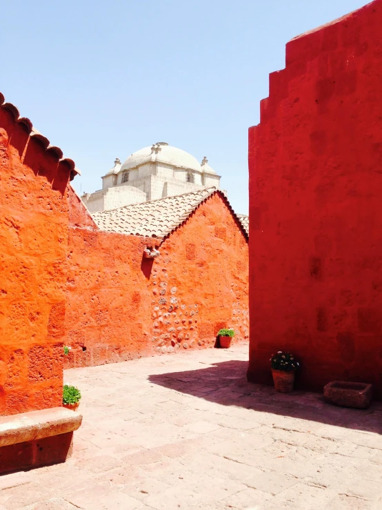 a red building with a bench in front of it, inspired by Luis Paret y Alcazar, temple of the sun, profile image, patio, quechua