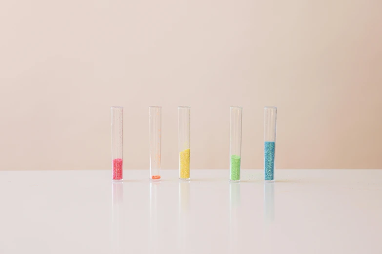 a row of test tubes filled with colored sand, inspired by Damien Hirst, kinetic pointillism, minimal palette, rinko kawauchi, multicoloured, multicolor