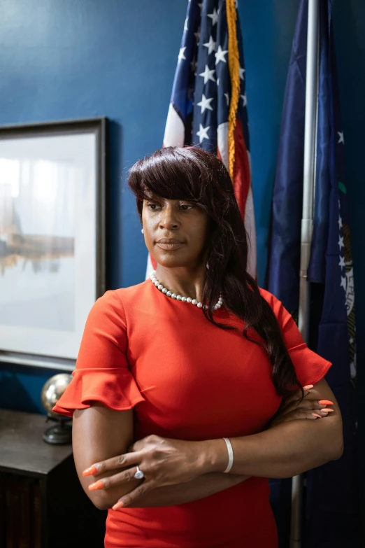 a woman in a red dress standing in front of an american flag, a portrait, on a desk, vanessa blue, looking serious, sharp focus »