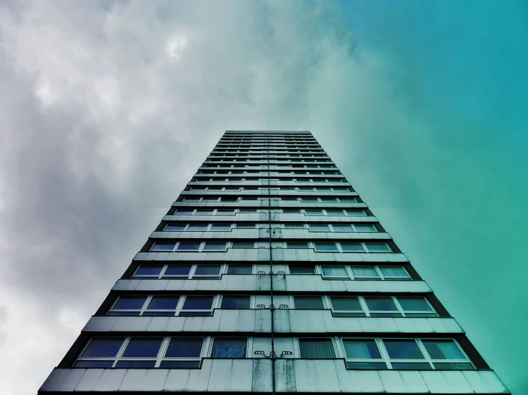 a tall building with a blue sky in the background, an album cover, unsplash, brutalism, grey skies, teal sky, ten flats, towering high up over your view