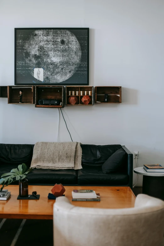 a living room filled with furniture and a flat screen tv, inspired by Donald Judd, unsplash contest winner, leather couch, moons in background, hanging cables, table in front with a cup