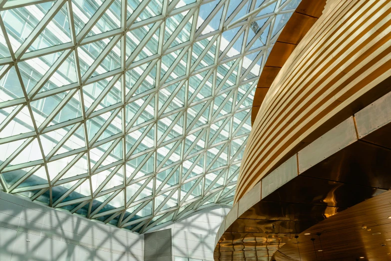 the inside of a building with a glass roof, inspired by Buckminster Fuller, pexels contest winner, arper's bazaar, inside a grand, golden curve structure, architectural finishes