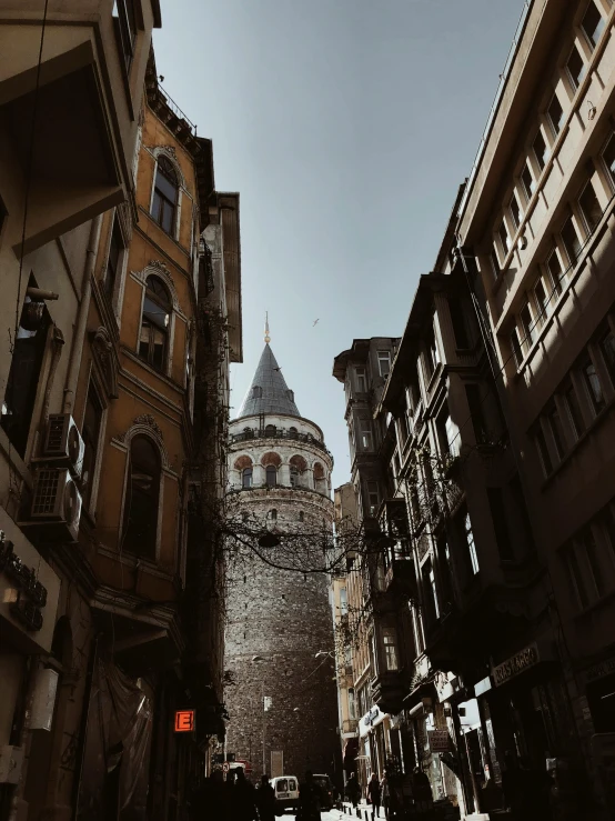 a group of people walking down a street next to tall buildings, inspired by Altoon Sultan, pexels contest winner, renaissance, turrets, turkey, 🚿🗝📝, view from ground level