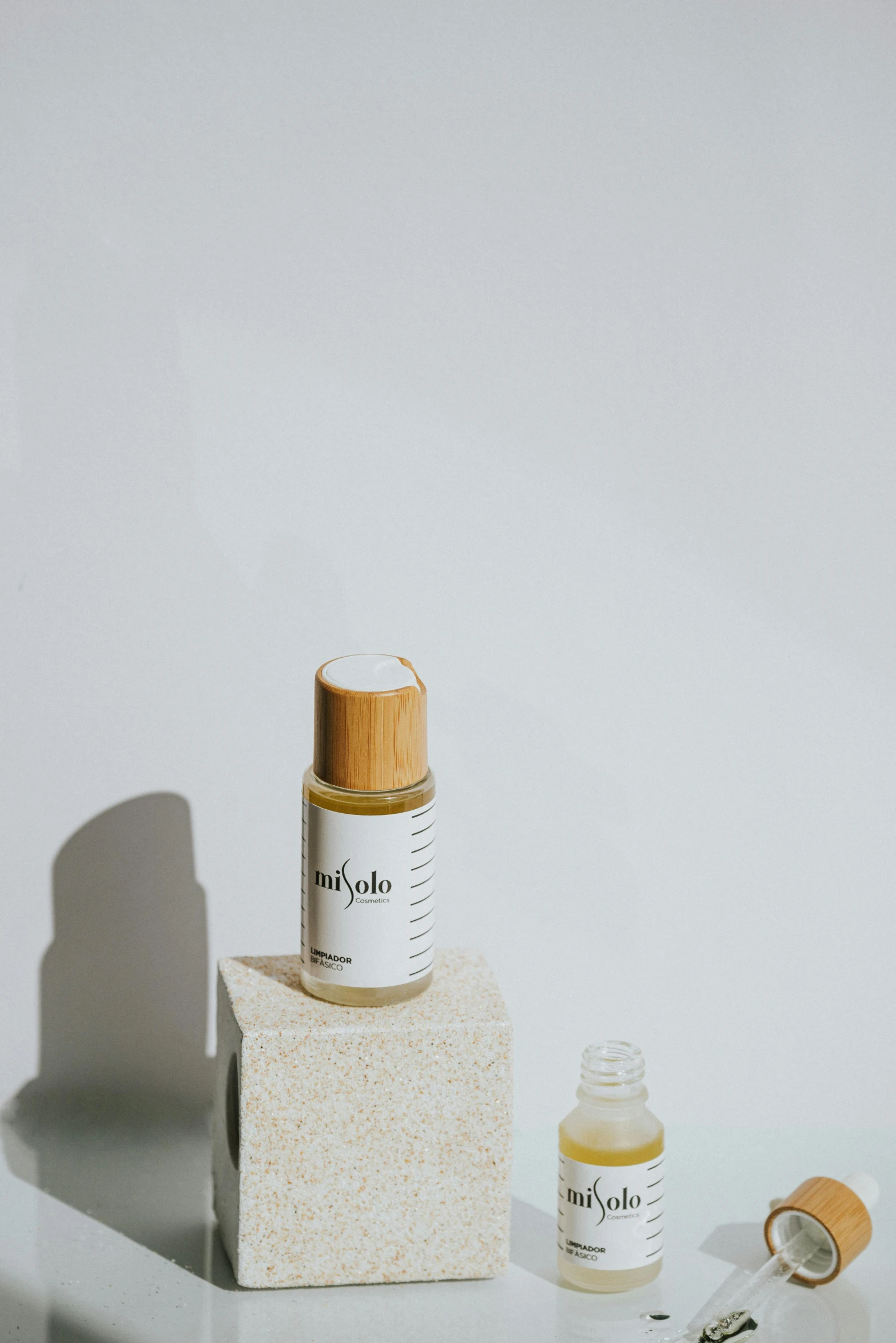 a bottle of essential oil next to a small bottle of essential oil, unsplash, visual art, product label, superfine inklines, 3/4 front view, yotobi