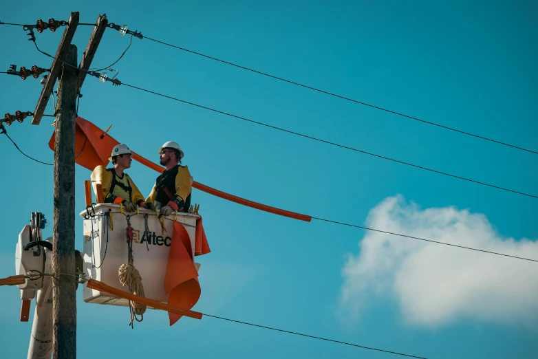 a man that is sitting on top of a bucket, by Lee Loughridge, pexels contest winner, happening, orange electricity, te pae, blue sky, people at work