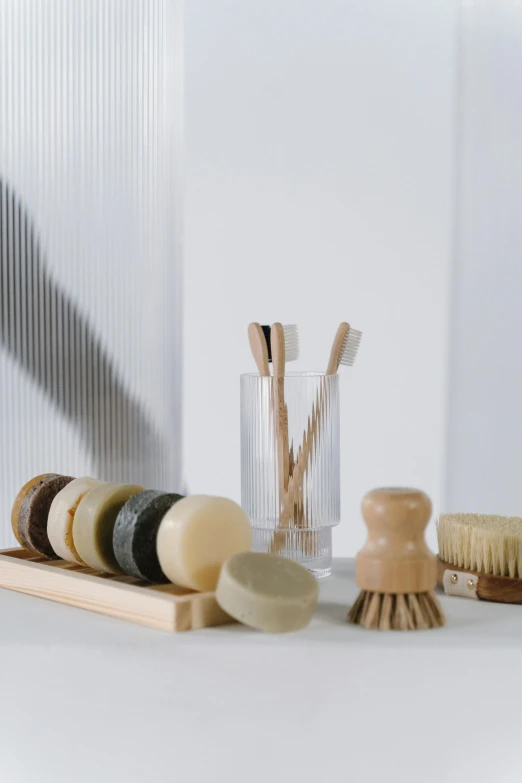 a couple of brushes sitting on top of a counter, carved soap, sustainable materials, collection product, translucent