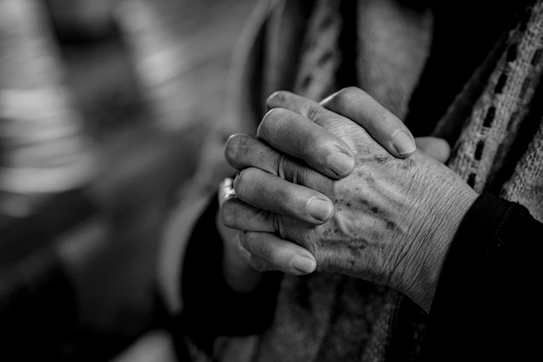 a close up of a person holding a cigarette, a black and white photo, by Matija Jama, unsplash, renaissance, nursing home, prayer hands, wrinkles, dressed in a worn