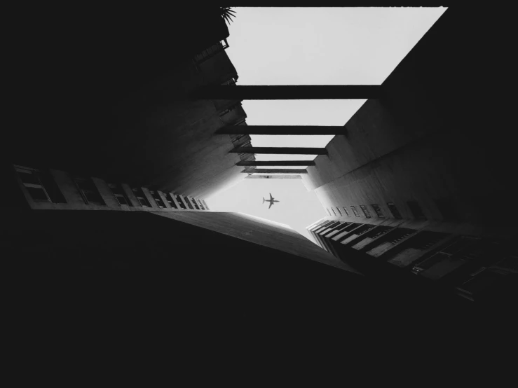 a black and white photo of a light at the end of a tunnel, inspired by Alexander Rodchenko, unsplash contest winner, brutalism, flying over dark gotham, alessio albi, jumping towards viewer, stacked image