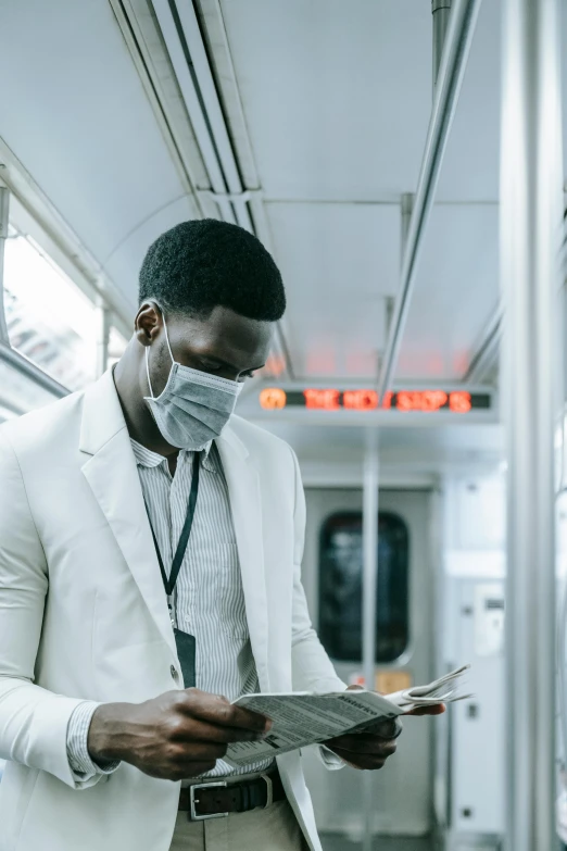 a man wearing a face mask reading a newspaper, pexels contest winner, afrofuturism, wearing a white tuxedo, subways, (doctor), [ cinematic