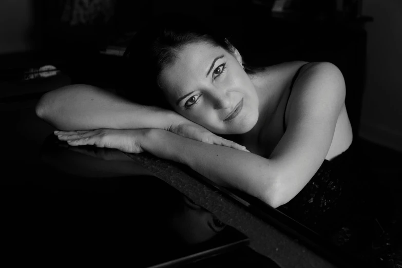a black and white photo of a woman leaning on a piano, by Emma Andijewska, sheryl sandberg, bogdan rezunenko, neri oxman, alexi zaitsev
