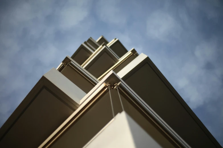 a tall building with a blue sky in the background, an art deco sculpture, inspired by Donald Judd, unsplash, beige and gold tones, bottom body close up, angular metal, ignant