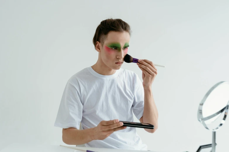 a man is doing makeup in front of a mirror, inspired by Russell Dongjun Lu, trending on pexels, hyperrealism, on a white table, avatar image, green face, attractive androgynous humanoid