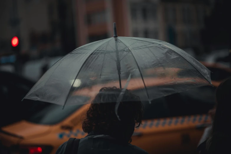 a woman holding an umbrella in the rain, inspired by Elsa Bleda, pexels contest winner, hyperrealism, taxi, underexposed grey, rectangle, instagram post