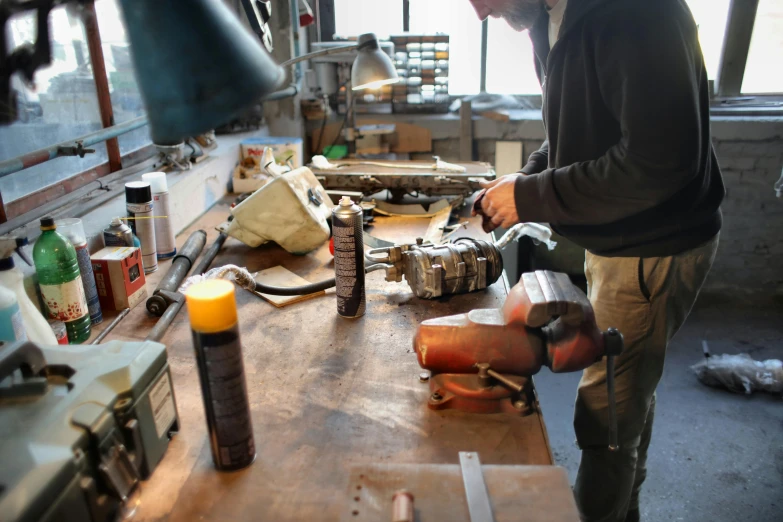 a man that is standing in front of a table, arbeitsrat für kunst, welding torches for arms, carefully crafted, toothpaste refinery, profile image