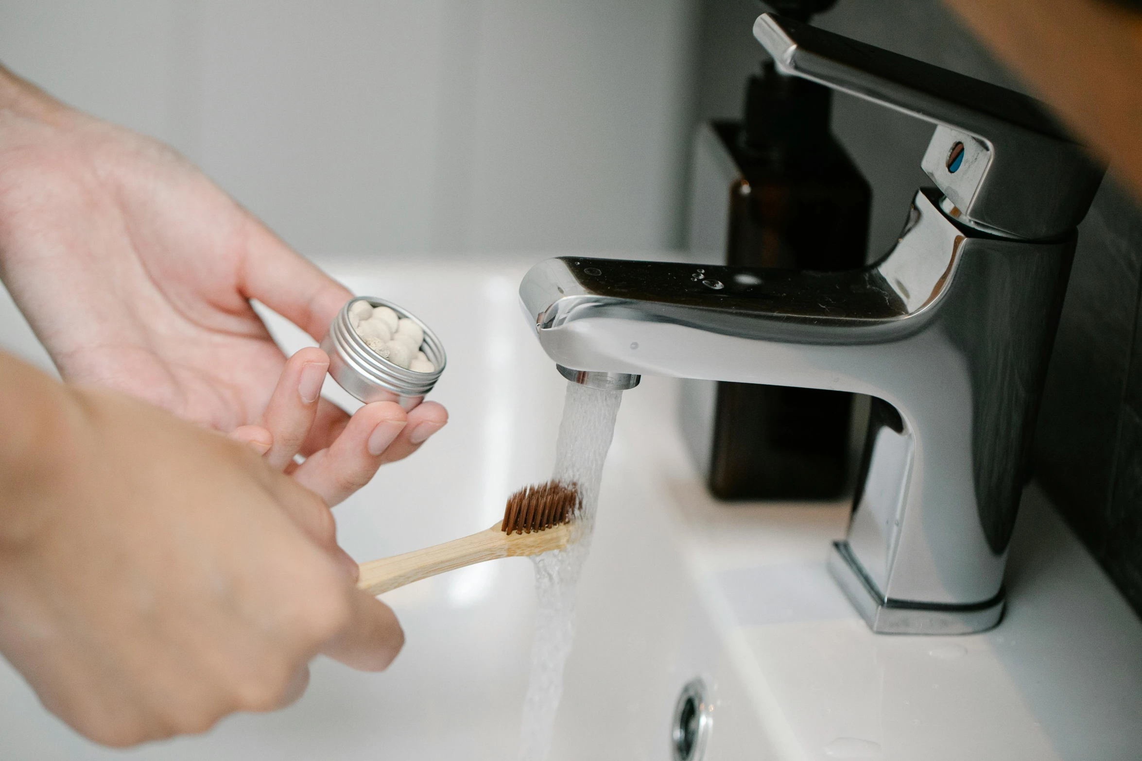 a person brushing their teeth with a toothbrush, by Nicolette Macnamara, unsplash, salt shaker, brown, eco, sink