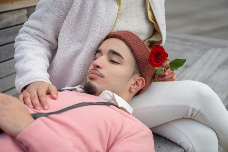 a man laying on a bench next to a woman, a colorized photo, trending on pexels, romanticism, rose crown, hispanic, sleepy fashion model face, growing out of a giant rose