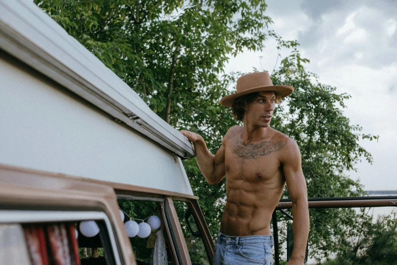 a shirtless man leaning on the back of a truck, trending on pexels, renaissance, cottagecore hippie, baggy clothing and hat, frank dillane, full extremely slim body