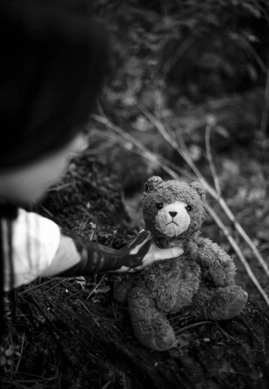 a black and white photo of a teddy bear, by Felix-Kelly, touching tree in a forest, broken toys, ! holding in his hand !, cinematic contrast