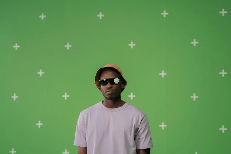 a man standing in front of a green screen, by Bascove, trending on pexels, wearing sunglasses and a cap, ( ( dark skin ) ), making of, childish