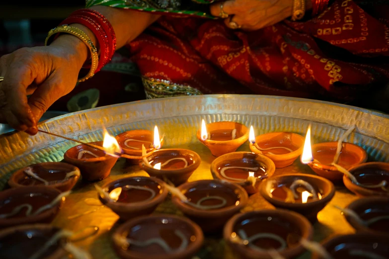 a close up of a person lighting candles, pexels contest winner, hurufiyya, indian patterns, thumbnail, 2 0 7 7, summer lighting