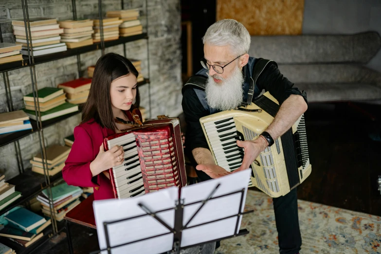 a man playing an accordion next to a little girl, by Julia Pishtar, pexels contest winner, danube school, overalls and a white beard, teaching, a pair of ribbed, in house