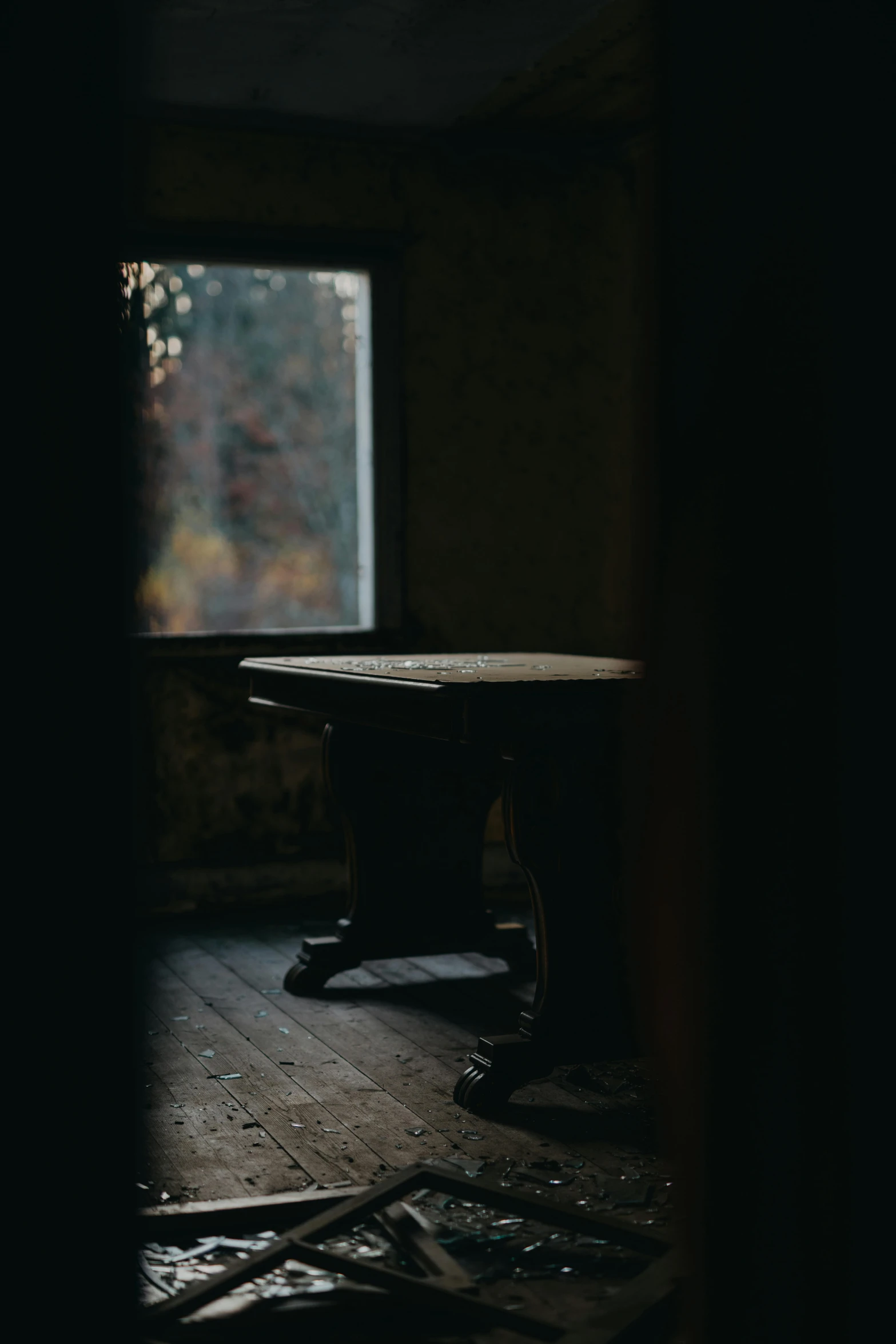 a table sitting on top of a wooden floor next to a window, unsplash contest winner, tonalism, inside a haunted house, looking left, gaming table, black furniture