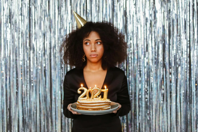 a woman holding a cake with candles on it, an album cover, pexels, happening, new years eve, black teenage girl, silly, post graduate
